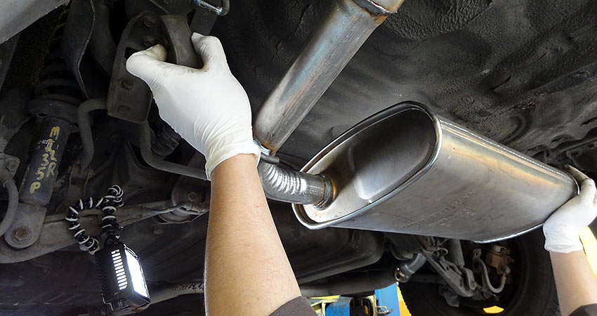 qualified mechanic fitting a car exhaust