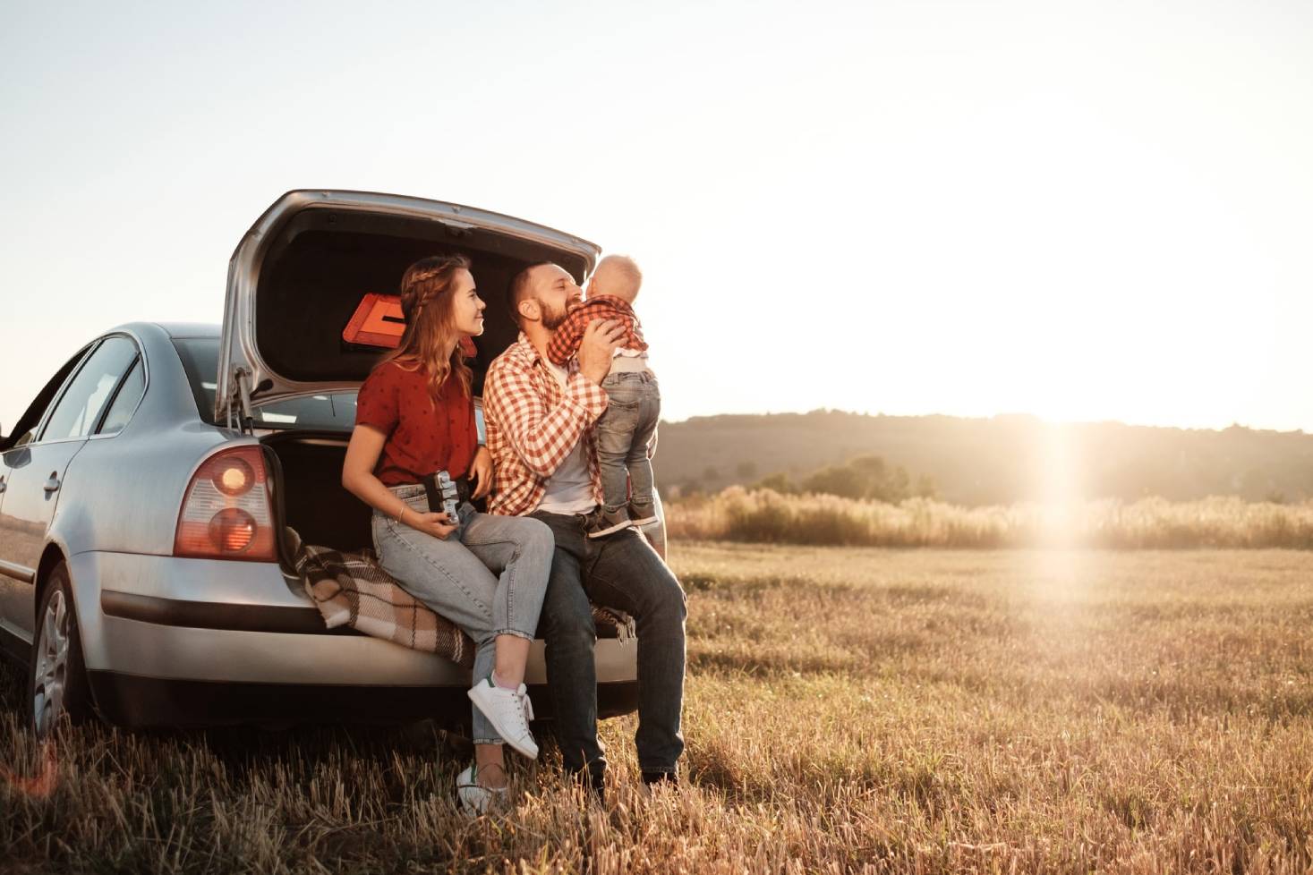 Family in car with sunset in background