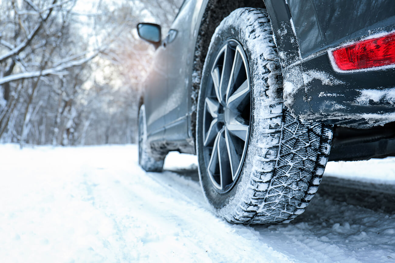 Close up of vehicle with winter tires on snow covered highway