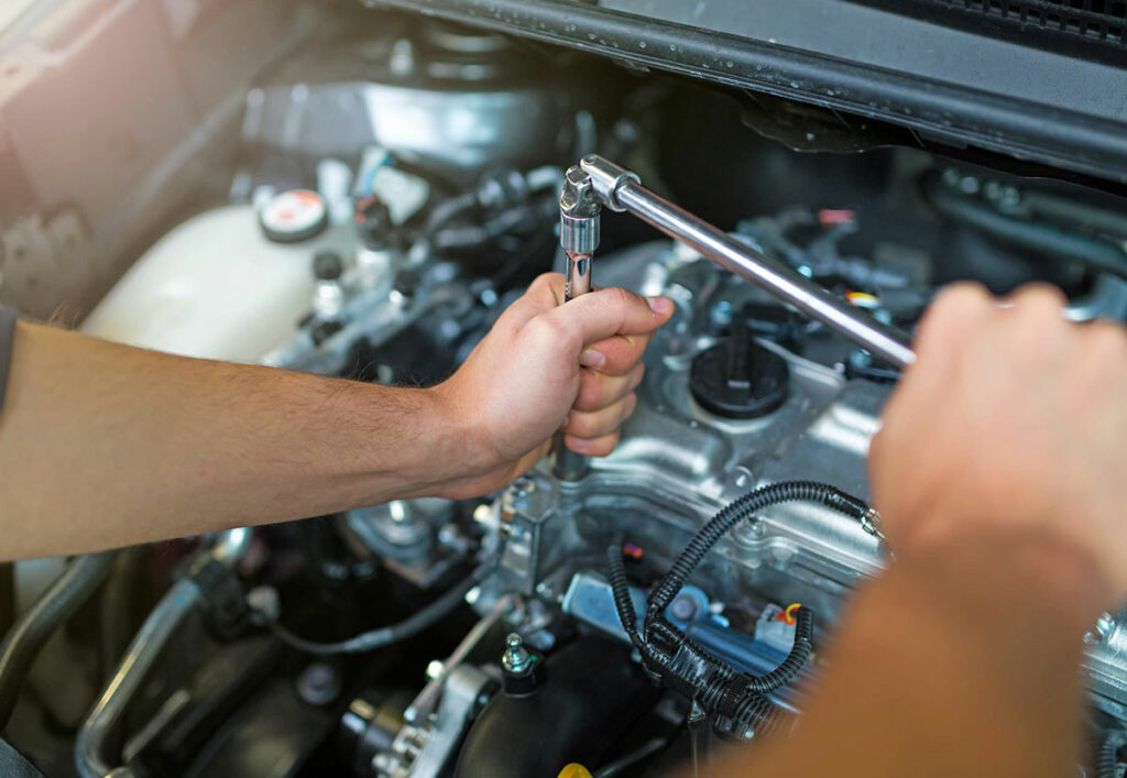 Male mechanic hands fixing the engine of a car.