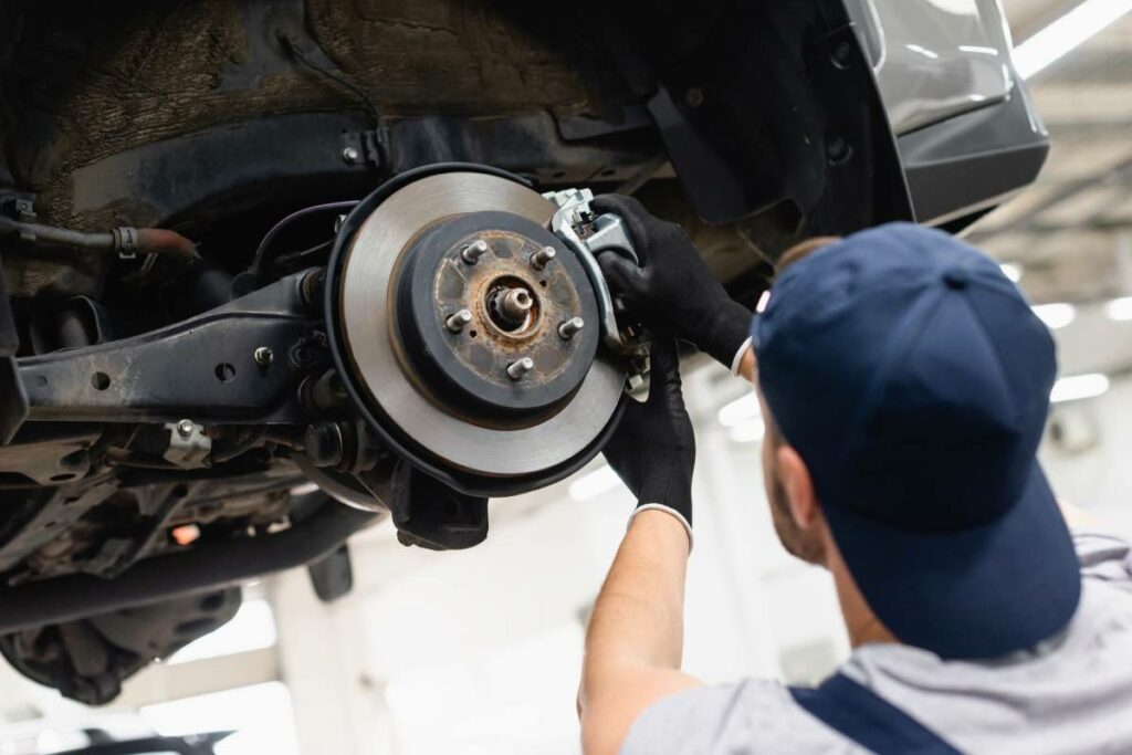 Male mechanic checking a vehicle’s brake system.