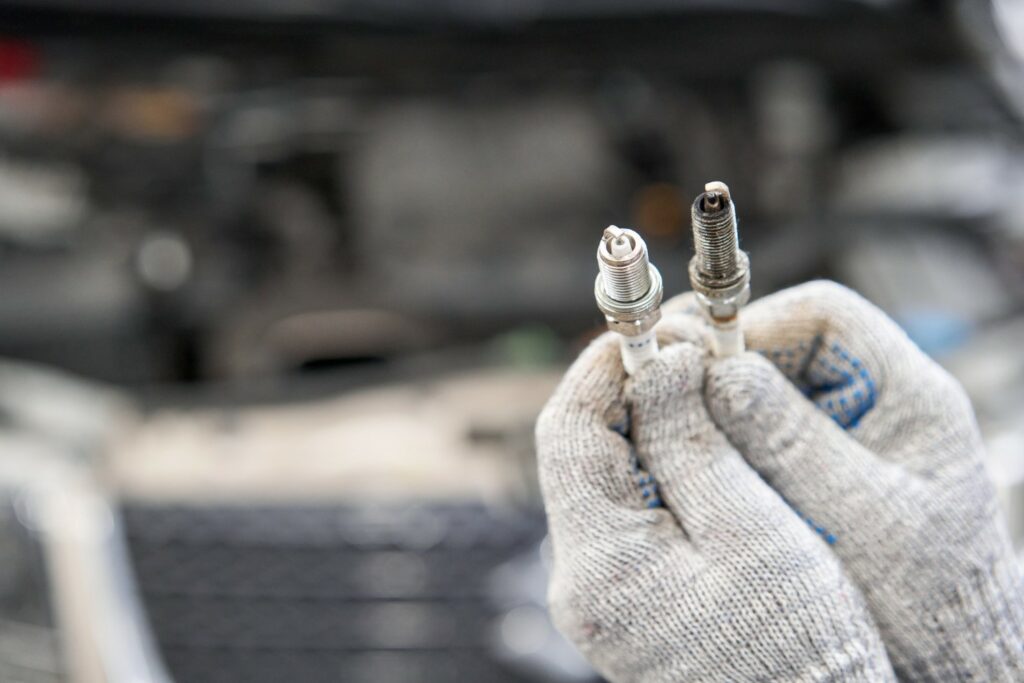 Person holding up together 2 spark plugs