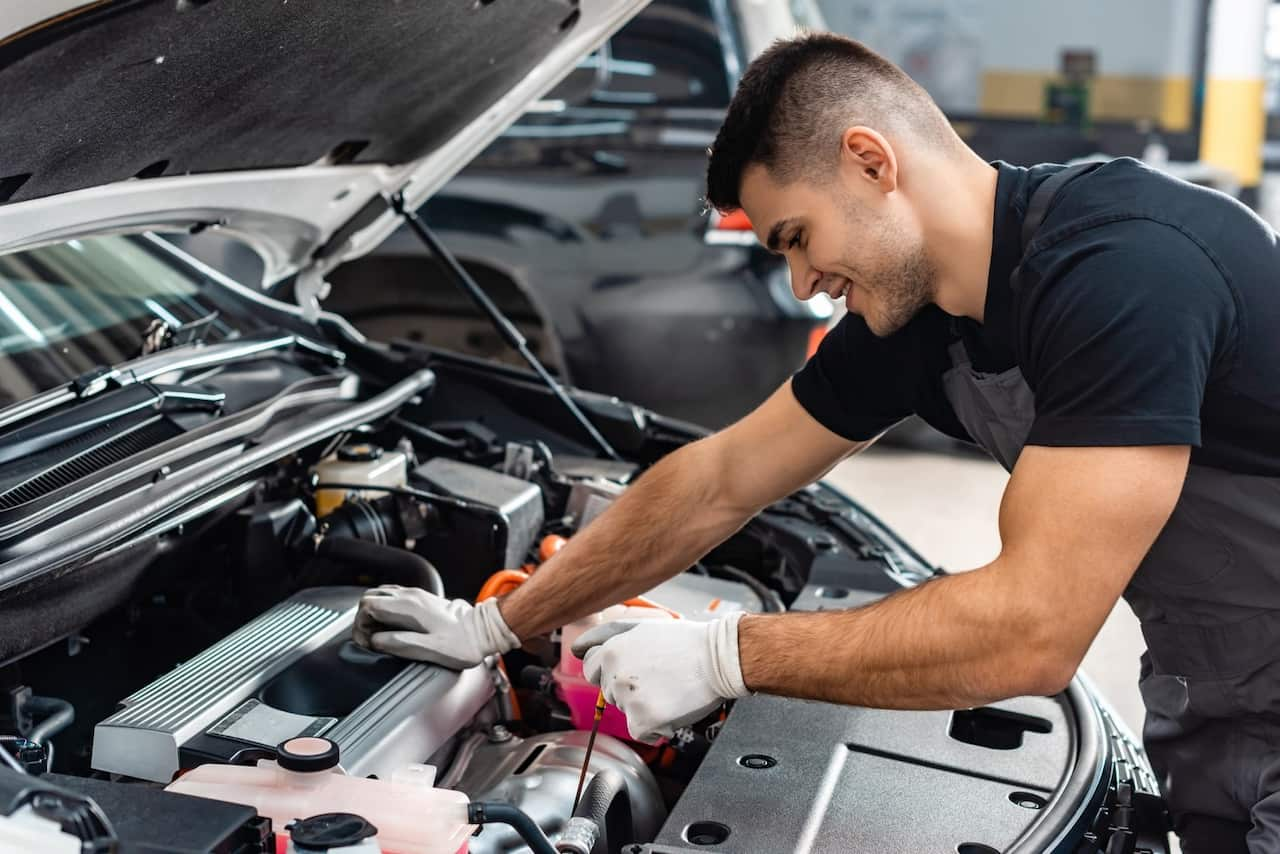 Mechanic checking engine oil