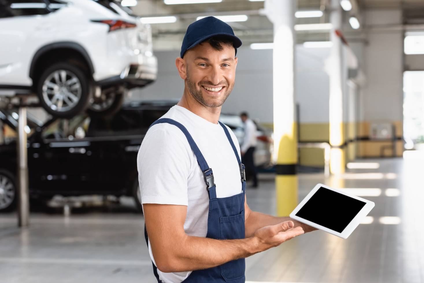 Friendly mechanic performing a tire rotation on an elevated vehicle