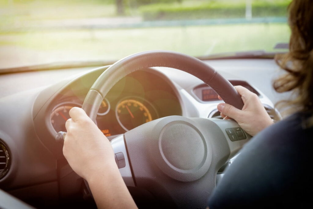 Woman sitting inside car looking at dashboard