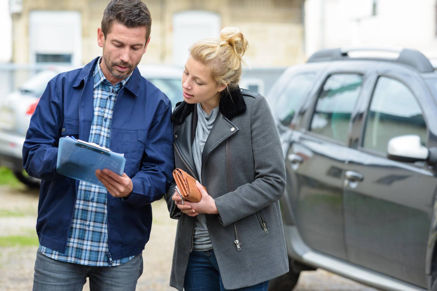 Reviewing a car inspection checklist with owner