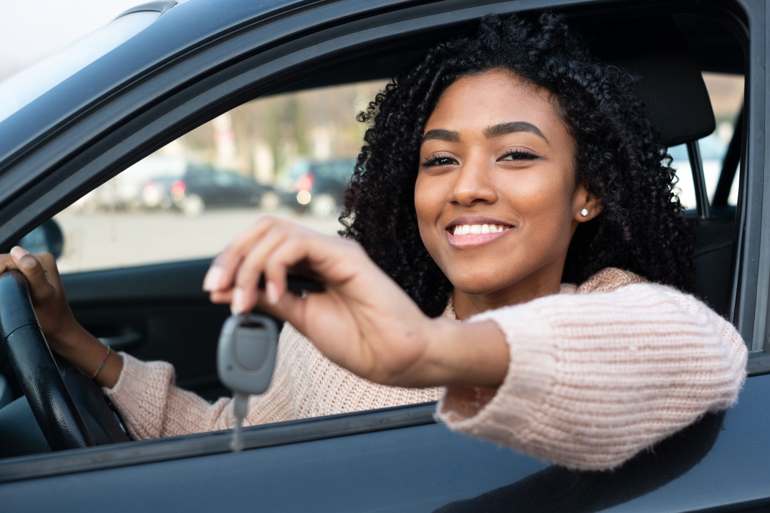 young woman smiling and passing the keys of her car to a mechanic for regular tune up