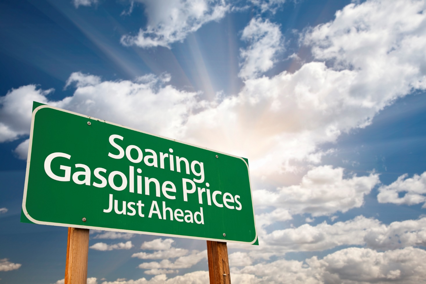 Road sign with words soaring gasoline prices just ahead